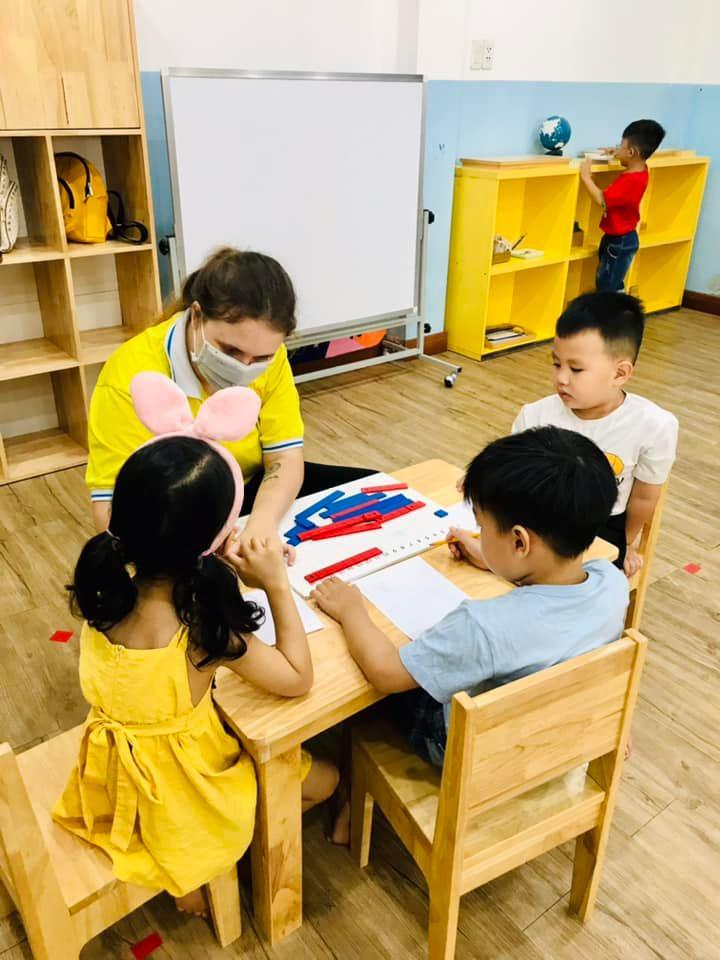 Giáo viên dạy các bé Toán học với học cụ trong phương pháp Montessori